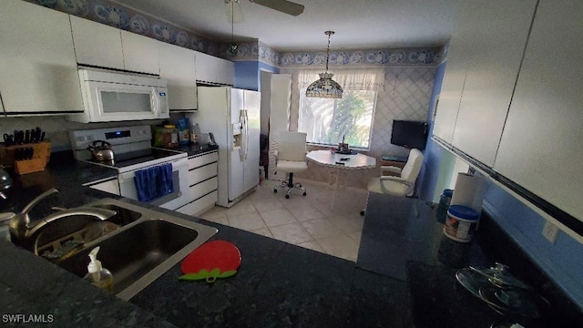 kitchen featuring sink, white appliances, white cabinets, light tile patterned flooring, and decorative light fixtures