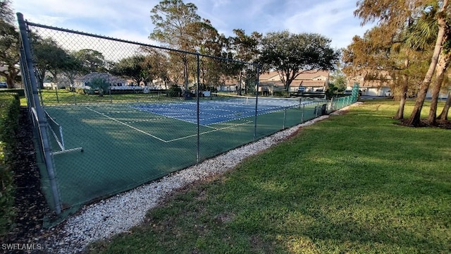 view of tennis court featuring a lawn