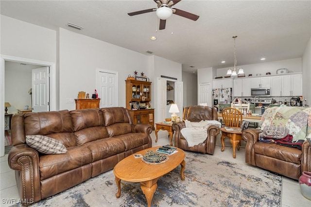 living room with ceiling fan with notable chandelier