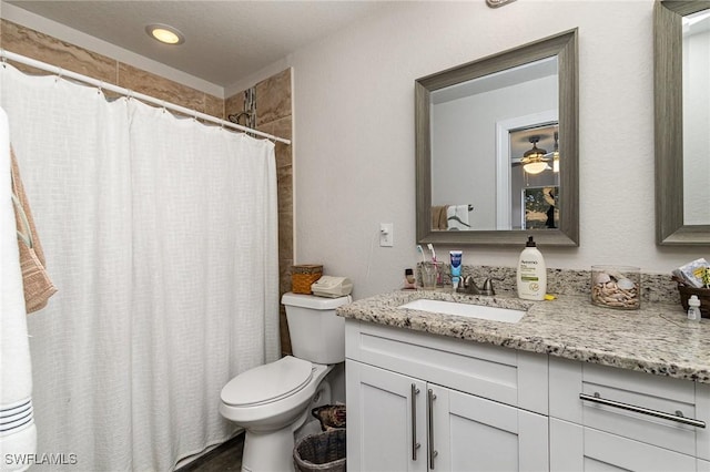 bathroom featuring a shower with shower curtain, vanity, ceiling fan, and toilet