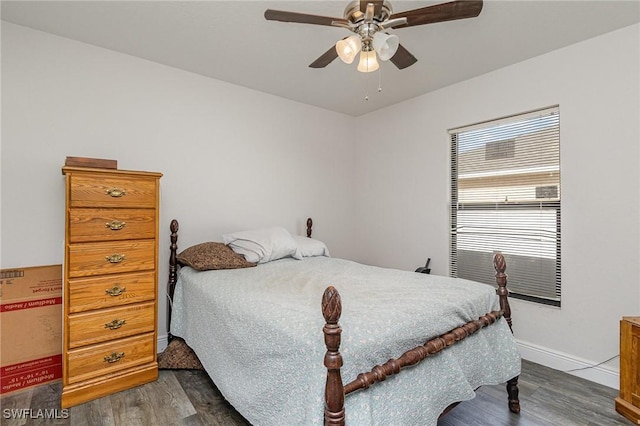 bedroom with dark hardwood / wood-style flooring and ceiling fan