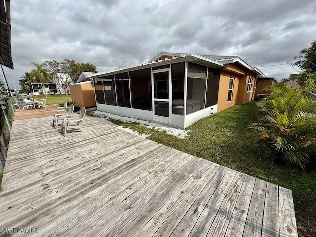 wooden deck featuring a sunroom and a lawn