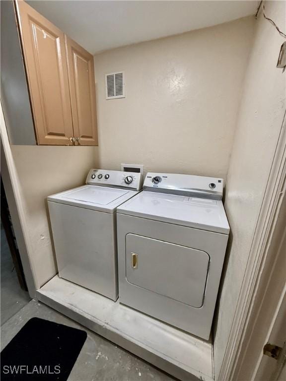 laundry area featuring cabinets and separate washer and dryer