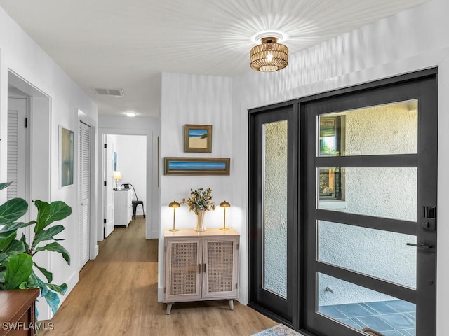 doorway featuring plenty of natural light and light hardwood / wood-style floors