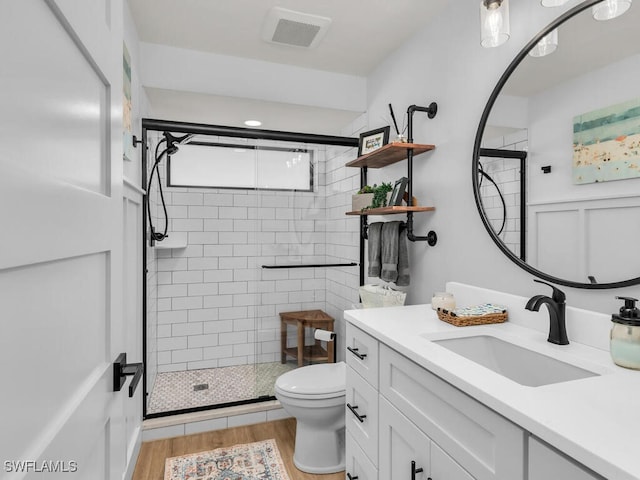 full bathroom with visible vents, toilet, a stall shower, vanity, and wood finished floors