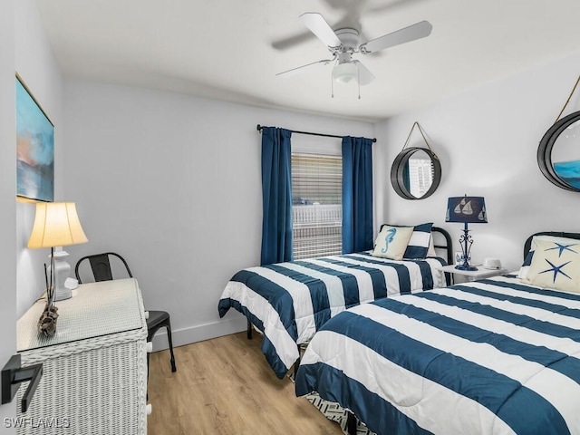 bedroom with ceiling fan, baseboards, and wood finished floors