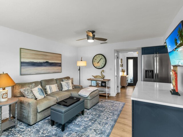 living room featuring light hardwood / wood-style flooring and ceiling fan