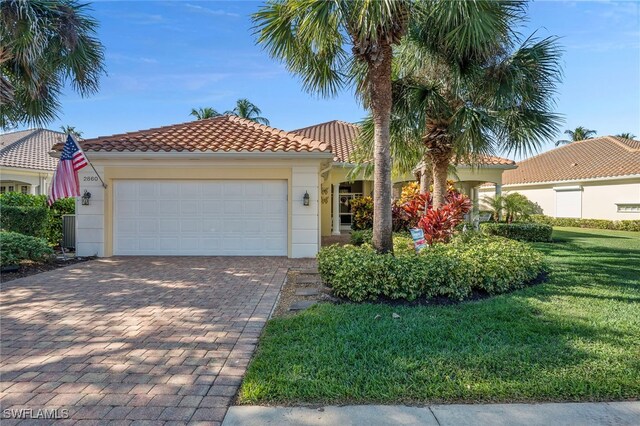 mediterranean / spanish-style home with a front yard and a garage