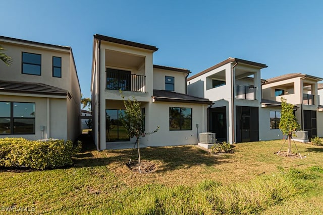 rear view of house featuring a lawn and central air condition unit