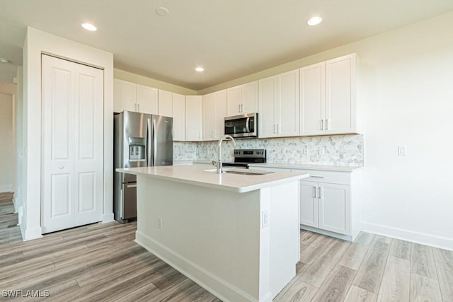 kitchen with white cabinets, stainless steel appliances, and light hardwood / wood-style floors