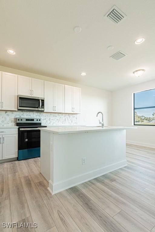 kitchen featuring white cabinets, light hardwood / wood-style floors, and appliances with stainless steel finishes