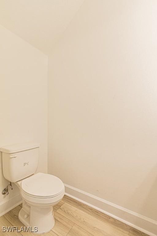 bathroom featuring wood-type flooring and toilet