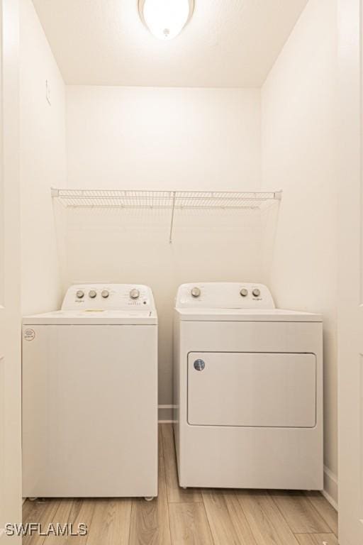 washroom with washer and dryer and light wood-type flooring