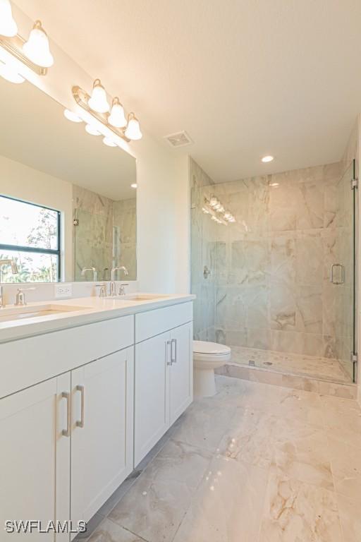 bathroom with toilet, an enclosed shower, and vanity