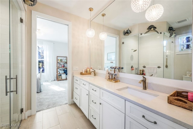 bathroom featuring tile patterned flooring, vanity, and a shower with door