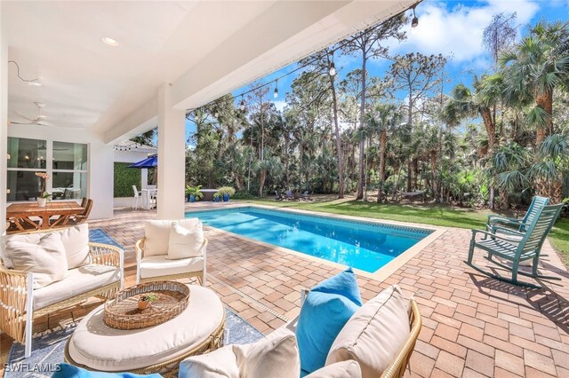 view of swimming pool featuring outdoor lounge area, ceiling fan, and a patio area