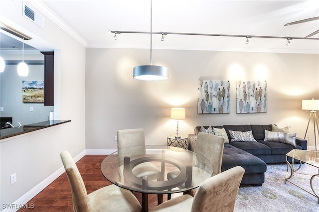 dining space with dark hardwood / wood-style flooring, rail lighting, ceiling fan, and crown molding