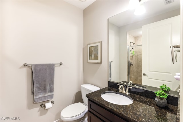 bathroom with vanity, toilet, and a shower with shower door