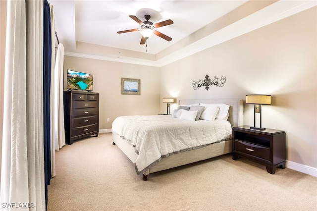 bedroom with ceiling fan, a raised ceiling, and light carpet