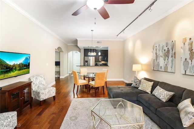 living room featuring rail lighting, dark hardwood / wood-style floors, ceiling fan, and crown molding