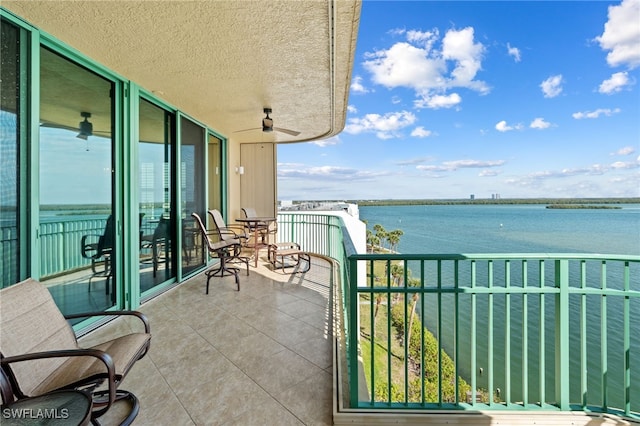 balcony featuring a water view and ceiling fan