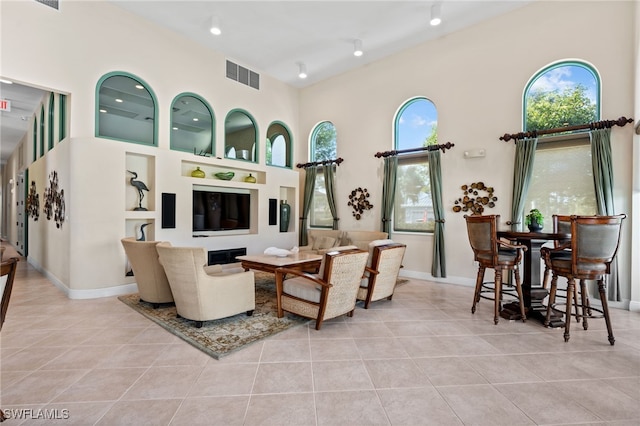 tiled living room featuring a towering ceiling