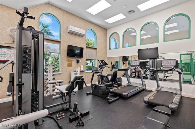 exercise room with a wall unit AC and high vaulted ceiling