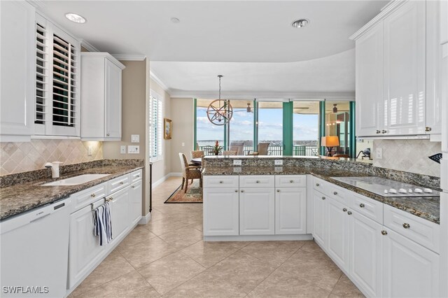 kitchen featuring tasteful backsplash, dark stone countertops, dishwasher, and white cabinets