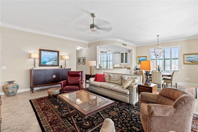 living room with ceiling fan with notable chandelier, ornamental molding, and light tile patterned floors