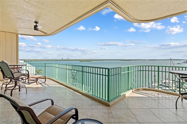 balcony featuring a water view and ceiling fan