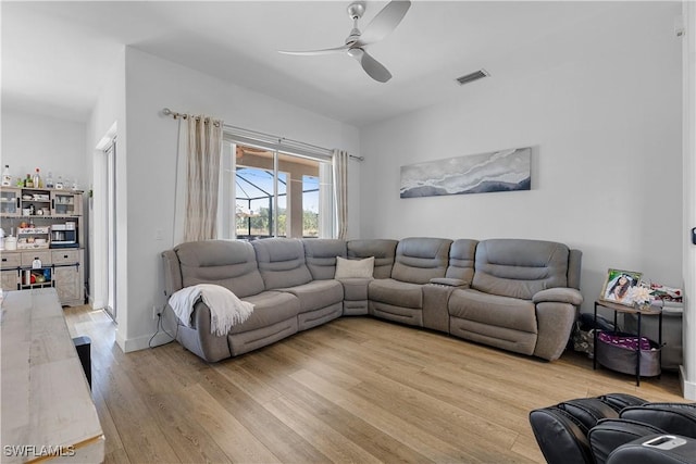 living room with ceiling fan and light hardwood / wood-style flooring