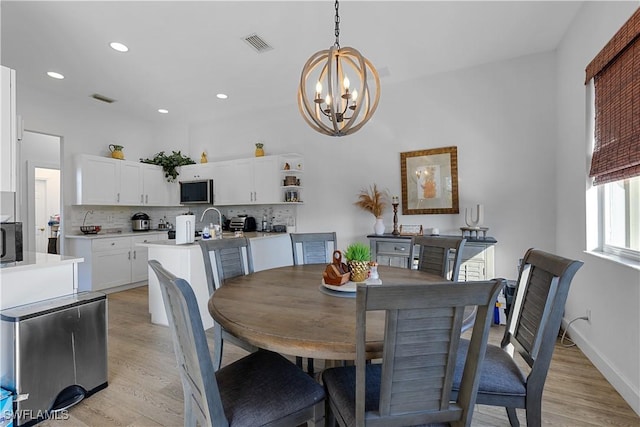 dining space featuring a notable chandelier and light hardwood / wood-style flooring