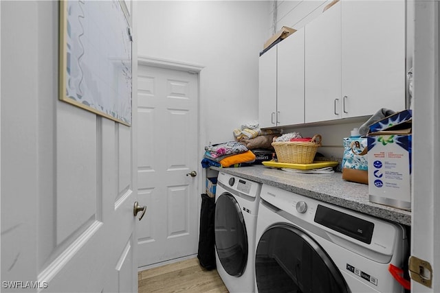 laundry area featuring light hardwood / wood-style flooring, cabinets, and independent washer and dryer