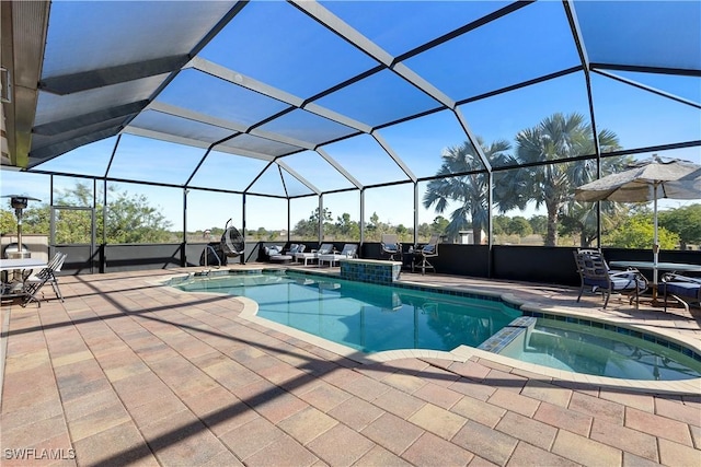 view of pool featuring an in ground hot tub, glass enclosure, and a patio area