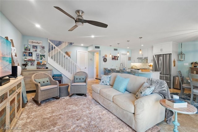 living room featuring ceiling fan and sink