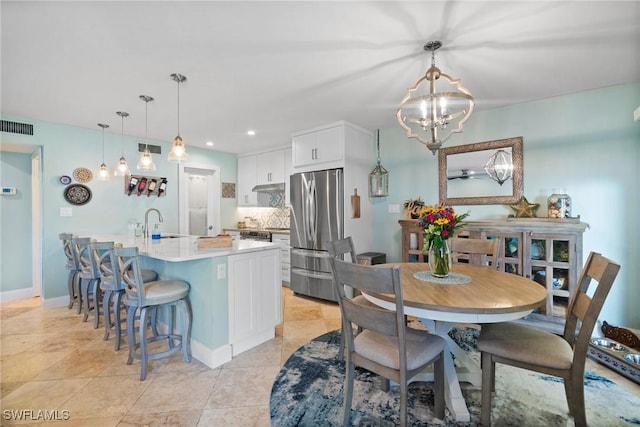 dining area with light tile patterned floors, an inviting chandelier, and sink