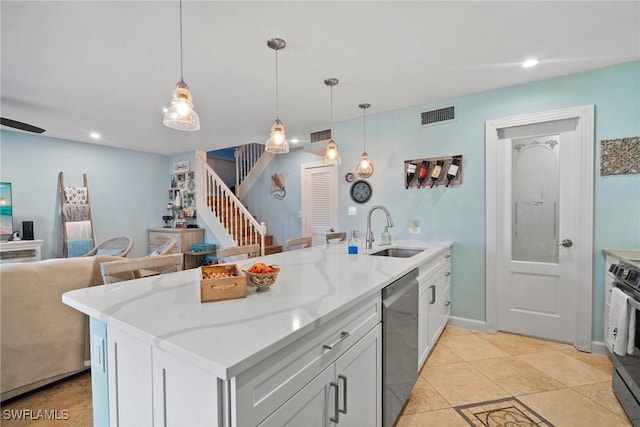 kitchen with light stone countertops, stainless steel appliances, sink, pendant lighting, and white cabinetry