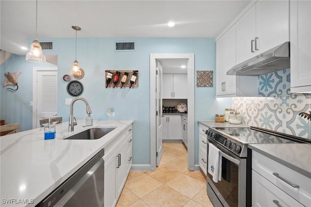 kitchen with light stone countertops, white cabinetry, sink, stainless steel appliances, and decorative light fixtures