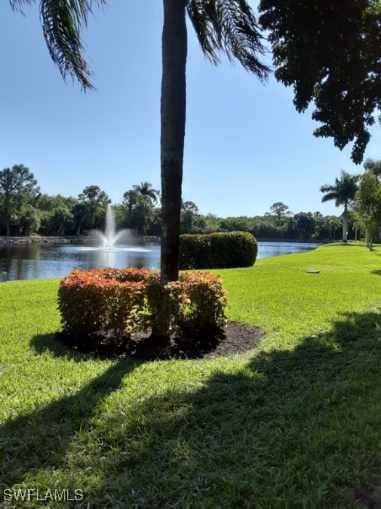 surrounding community with a lawn and a water view