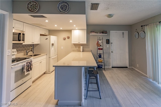 3 Bob O Link Ct Unit 3B, Naples, FL 34105 - kitchen with white cabinets, light wood-type flooring, white appliances, and sink