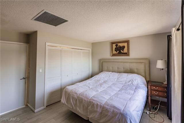 3 Bob O Link Ct Unit 3B, Naples, FL 34105 - bedroom with light wood finished floors, a textured ceiling, and a closet