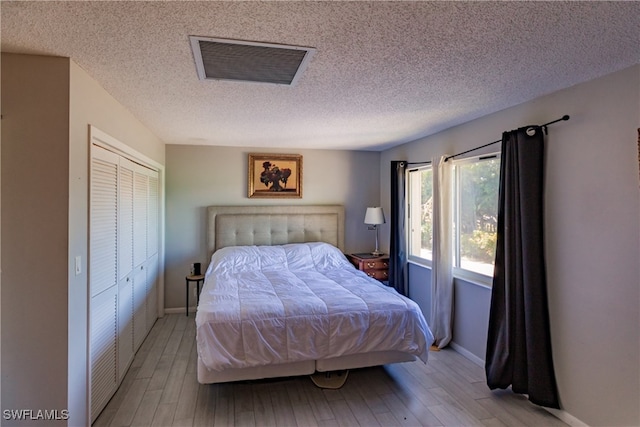 3 Bob O Link Ct Unit 3B, Naples, FL 34105 - bedroom featuring light wood finished floors, a closet, and a textured ceiling