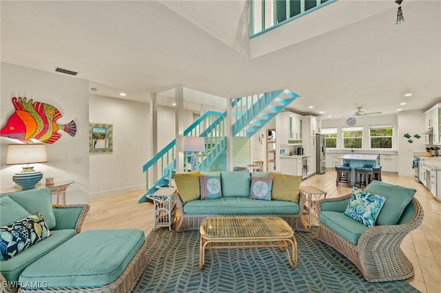 living room with light wood-type flooring and ceiling fan