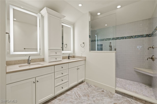 bathroom featuring a tile shower and vanity