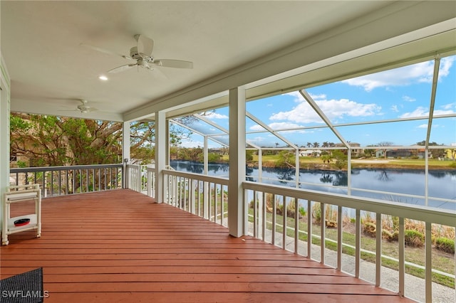 wooden deck featuring a water view, ceiling fan, and a lanai