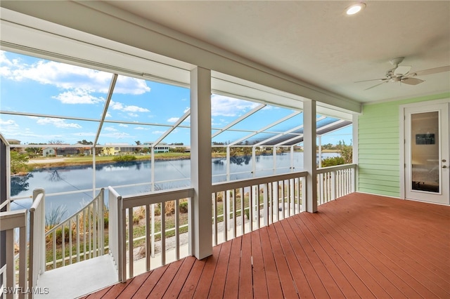 sunroom with a wealth of natural light, ceiling fan, and a water view