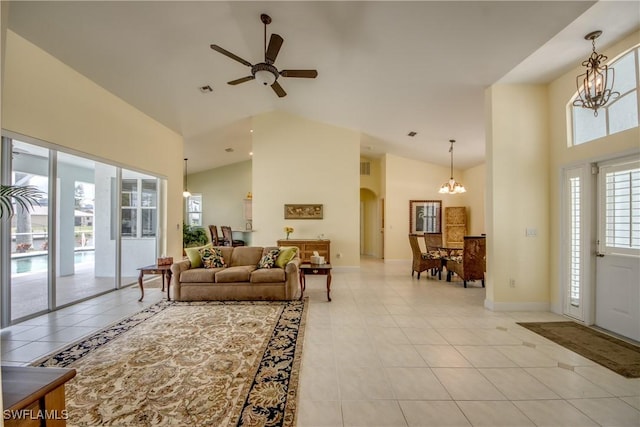 tiled living room featuring ceiling fan with notable chandelier and high vaulted ceiling