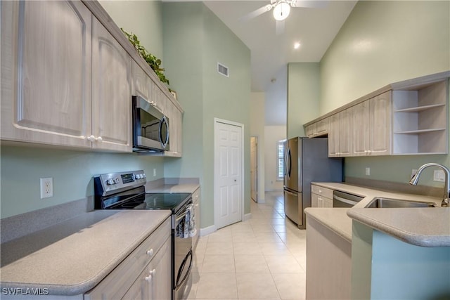 kitchen featuring sink, stainless steel appliances, high vaulted ceiling, kitchen peninsula, and light brown cabinetry