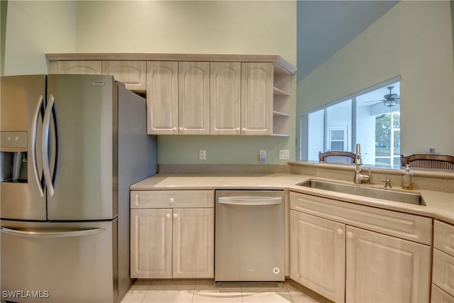 kitchen with ceiling fan, sink, light tile patterned flooring, and stainless steel appliances