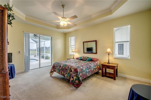 bedroom featuring a raised ceiling, ceiling fan, access to exterior, and multiple windows